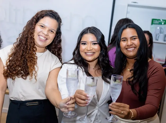 Alunas celebrando com brinde em evento Elas Sublimam